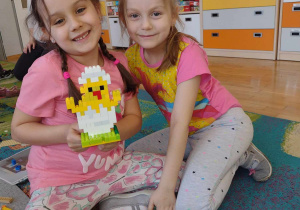Dwie dziewczynki prezentują swojego kurczaka z lego