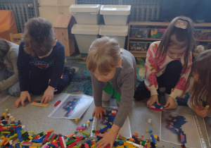 Troje dzieci buduje z klocków
