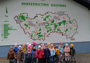 Dzieci z grupy II stoją przy mapie nadleśnictwa Kolumna
