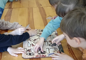 Dzieci z grupy IV podczas układania puzzli