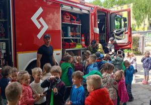 Dzieci stoją przed wozem strażackim