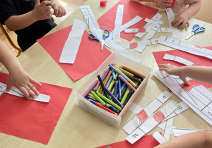 Dzieci z grupy II podczas wykonywania karty pracy z flagą