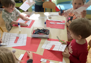 Dzieci z grupy II podczas wykonywania karty pracy z flagą