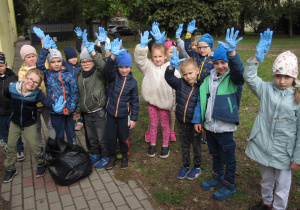 Dzieci z grupy V pokazują gumowe rękawiczki